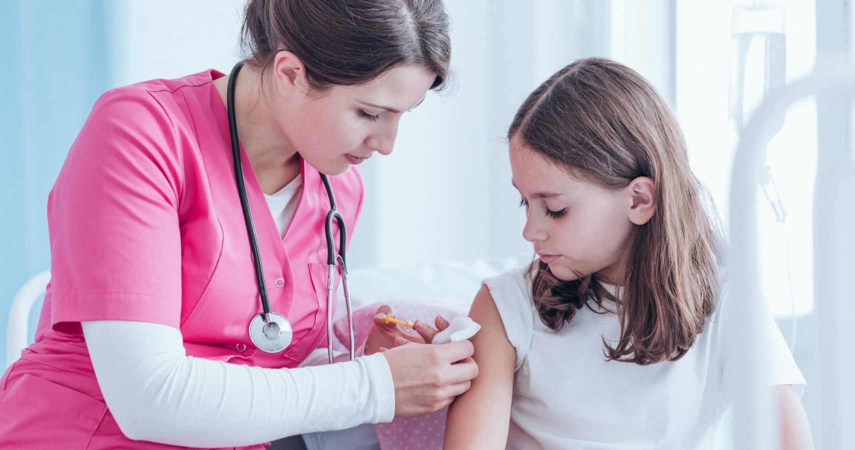 nurse giving teen girl vaccination