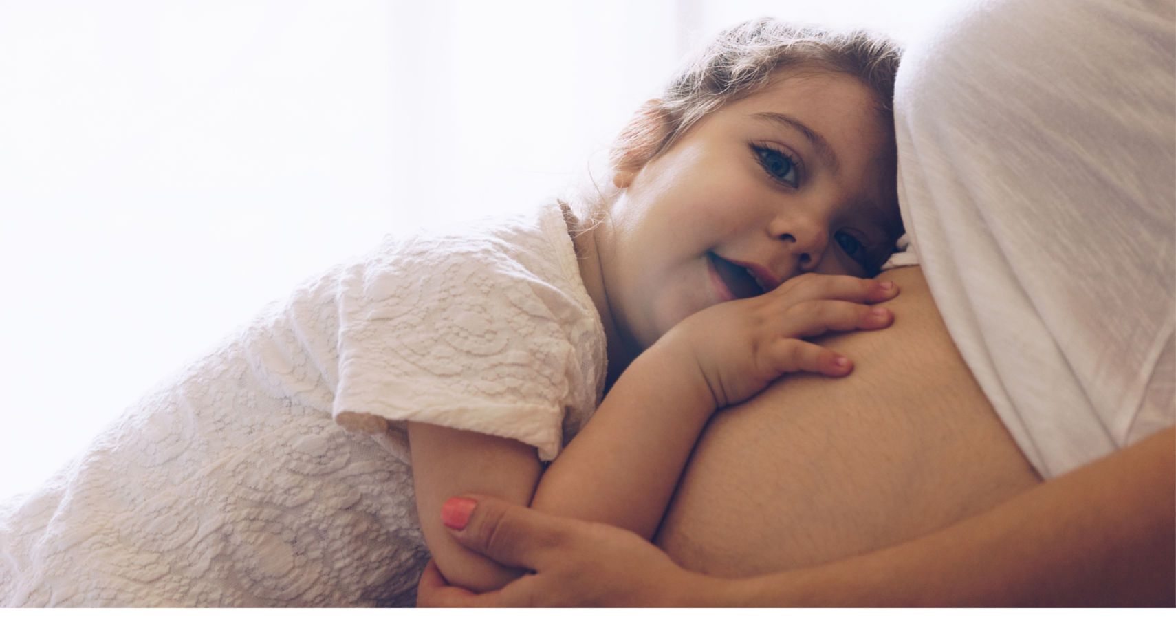girl hugging mom's pregnant belly