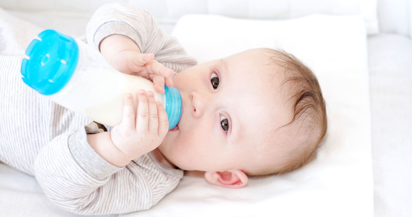 baby holding bottle drinking milk
