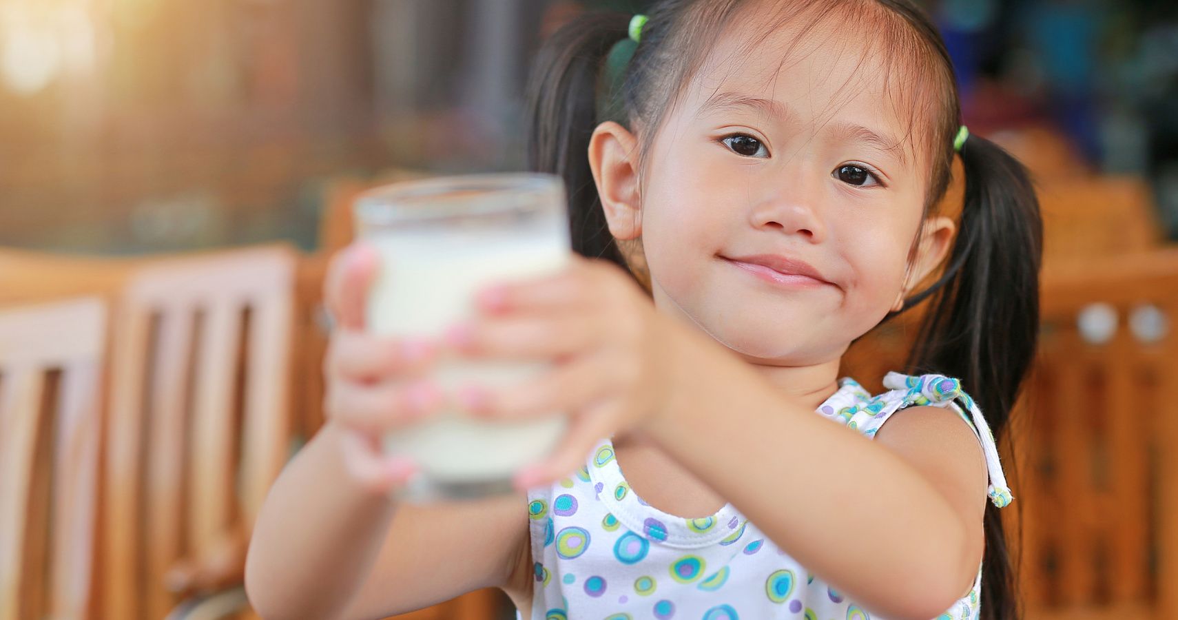 girl holding up a glass of milk