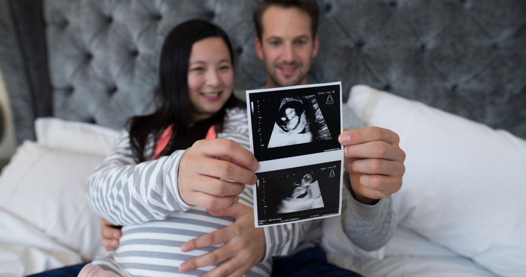 pregnant couple holding ultrasound photo