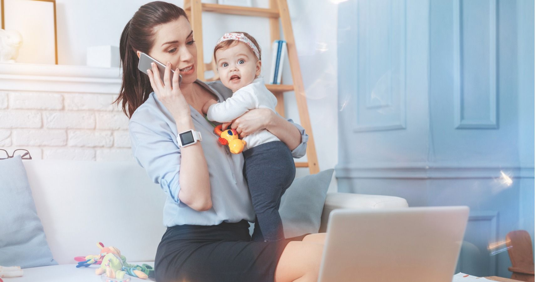 mom working on phone child in arms