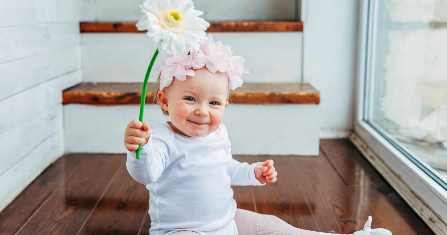 baby girl holding flower