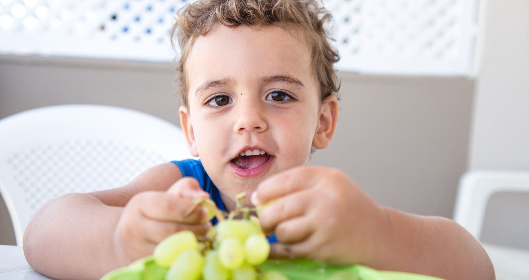 child eating grapes