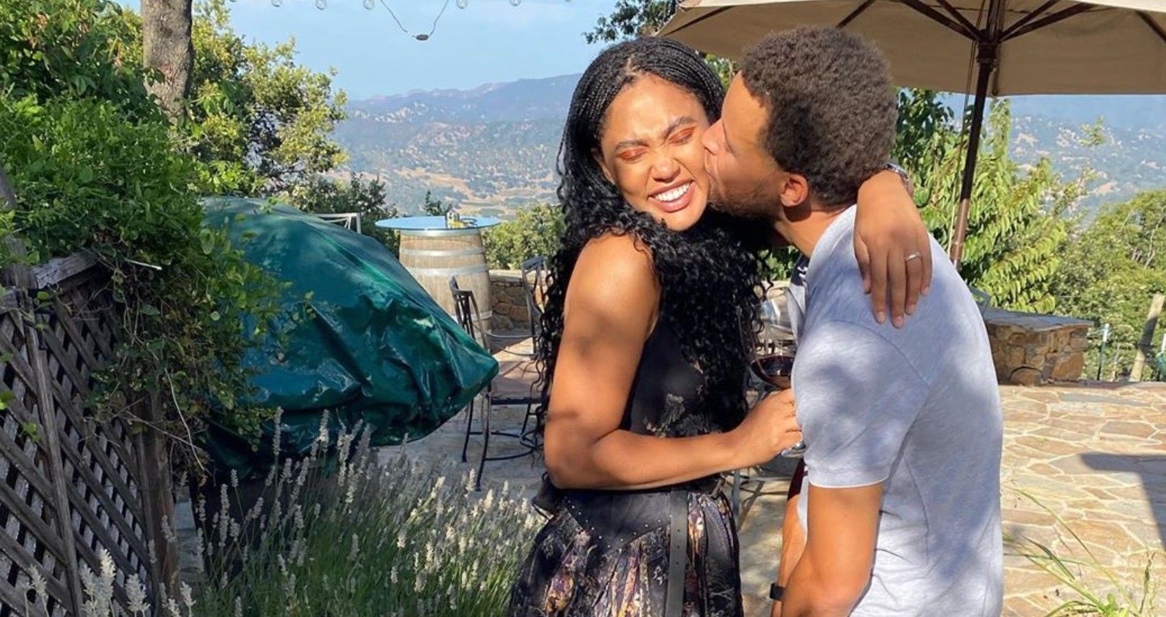 Stephen Curry giving Ayesha Curry a kiss on the cheek