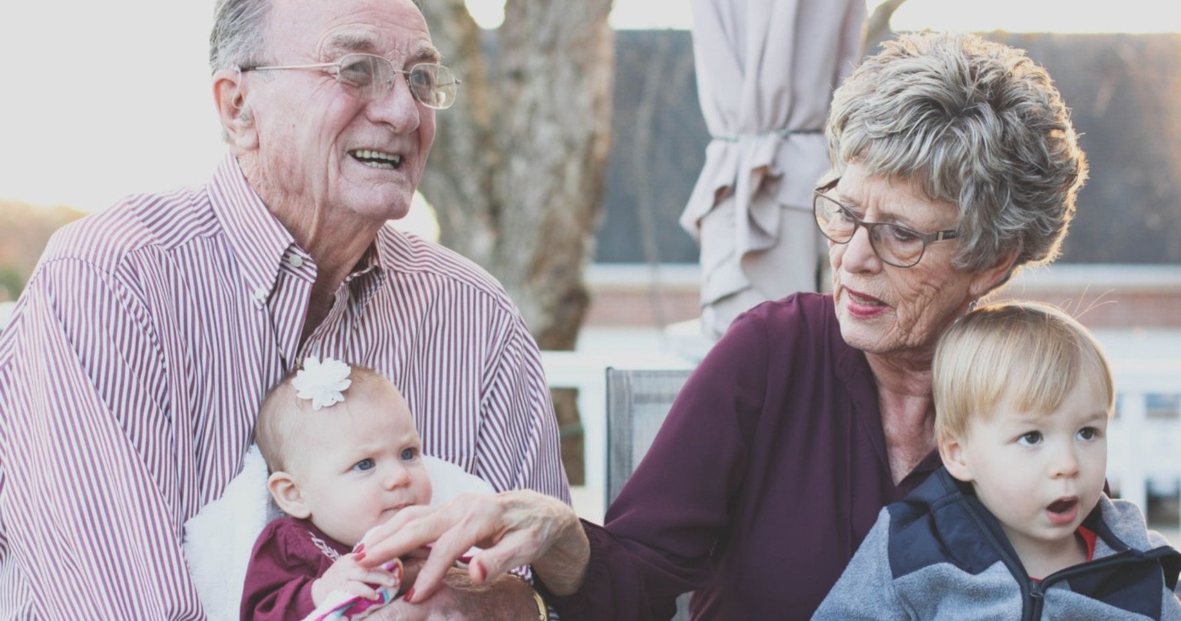 An elderly couple holding its grandkids