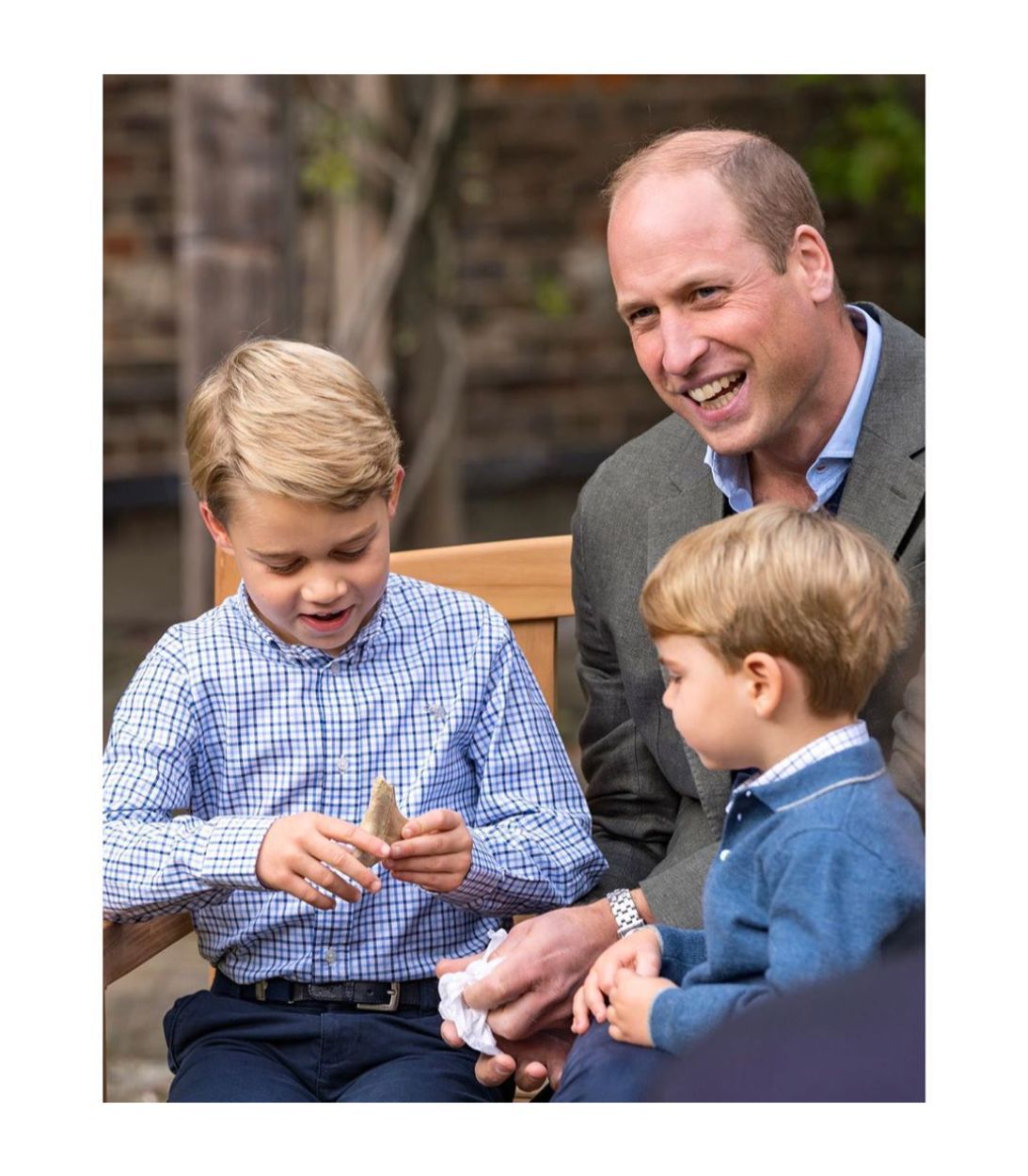 Prince William smiling with Prince George and Prince Louis