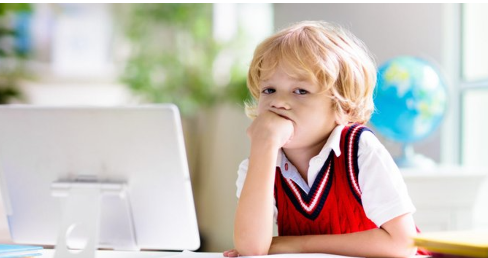 A child sitting on front of a computer