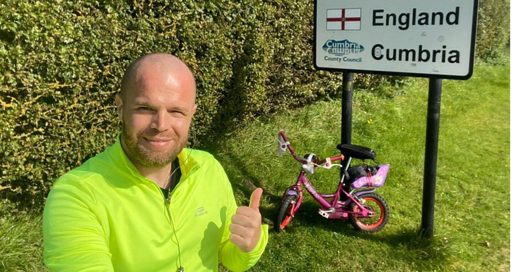Wesley Hamnett in front of pink bike and road sign