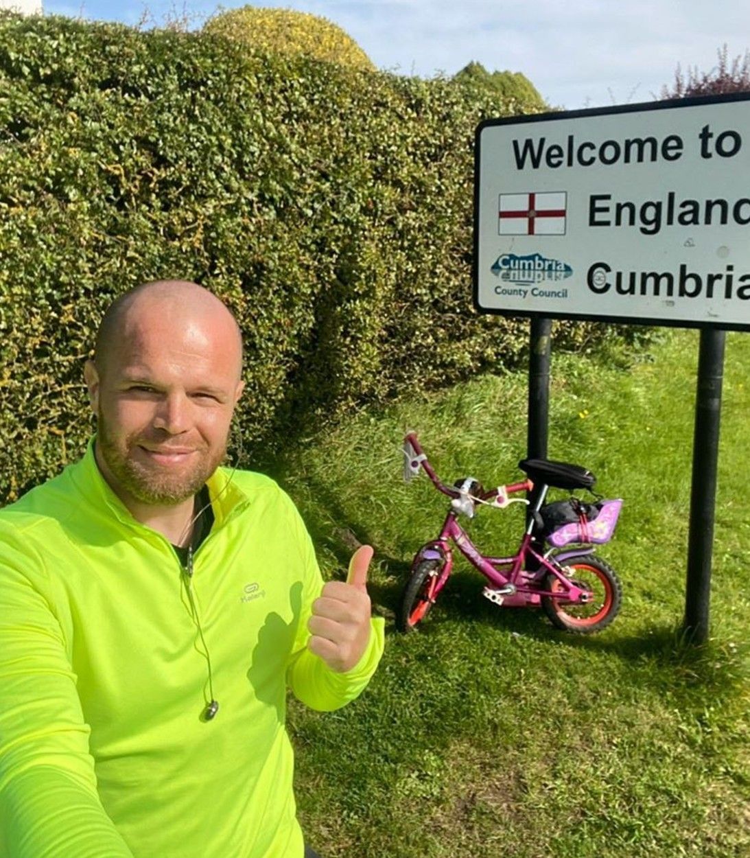 Welsey Hamnett in front of pink bike and road sign