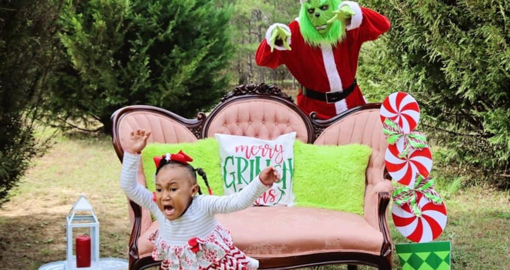 A little girl running from the grinch at a photoshoot