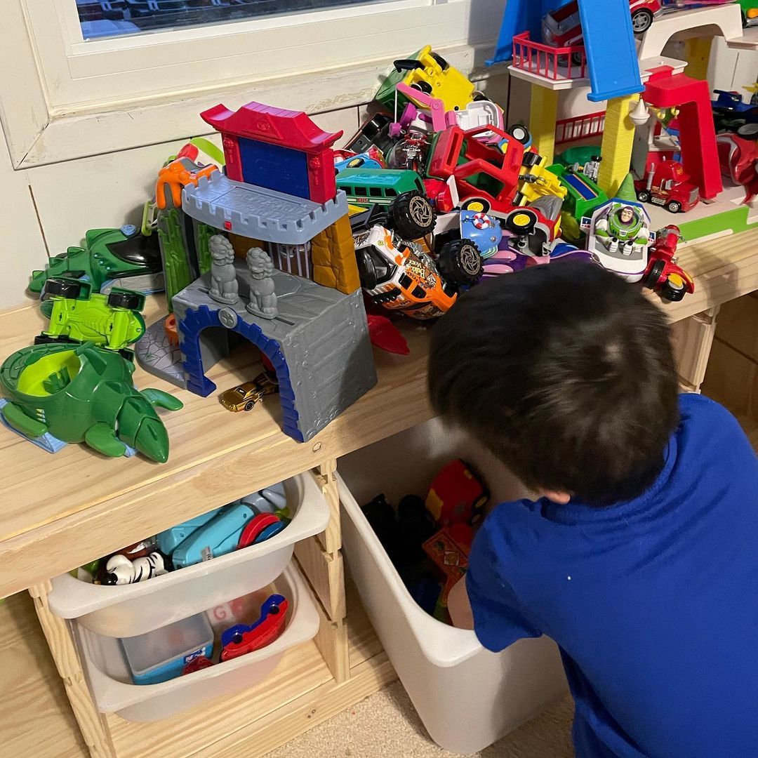 A boy looking through all of his toys