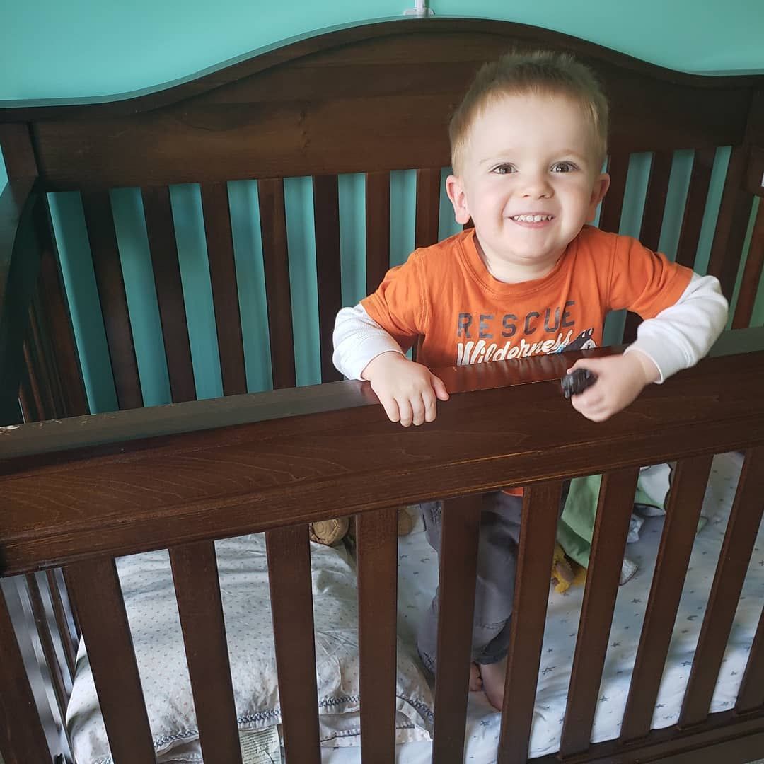 A boy standing up in his crib