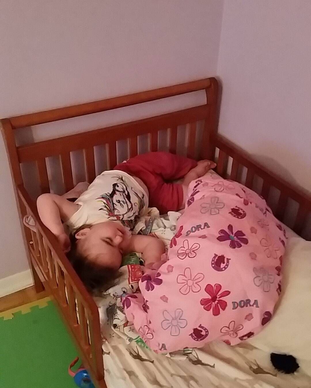 A child laying the wrong way on her bed