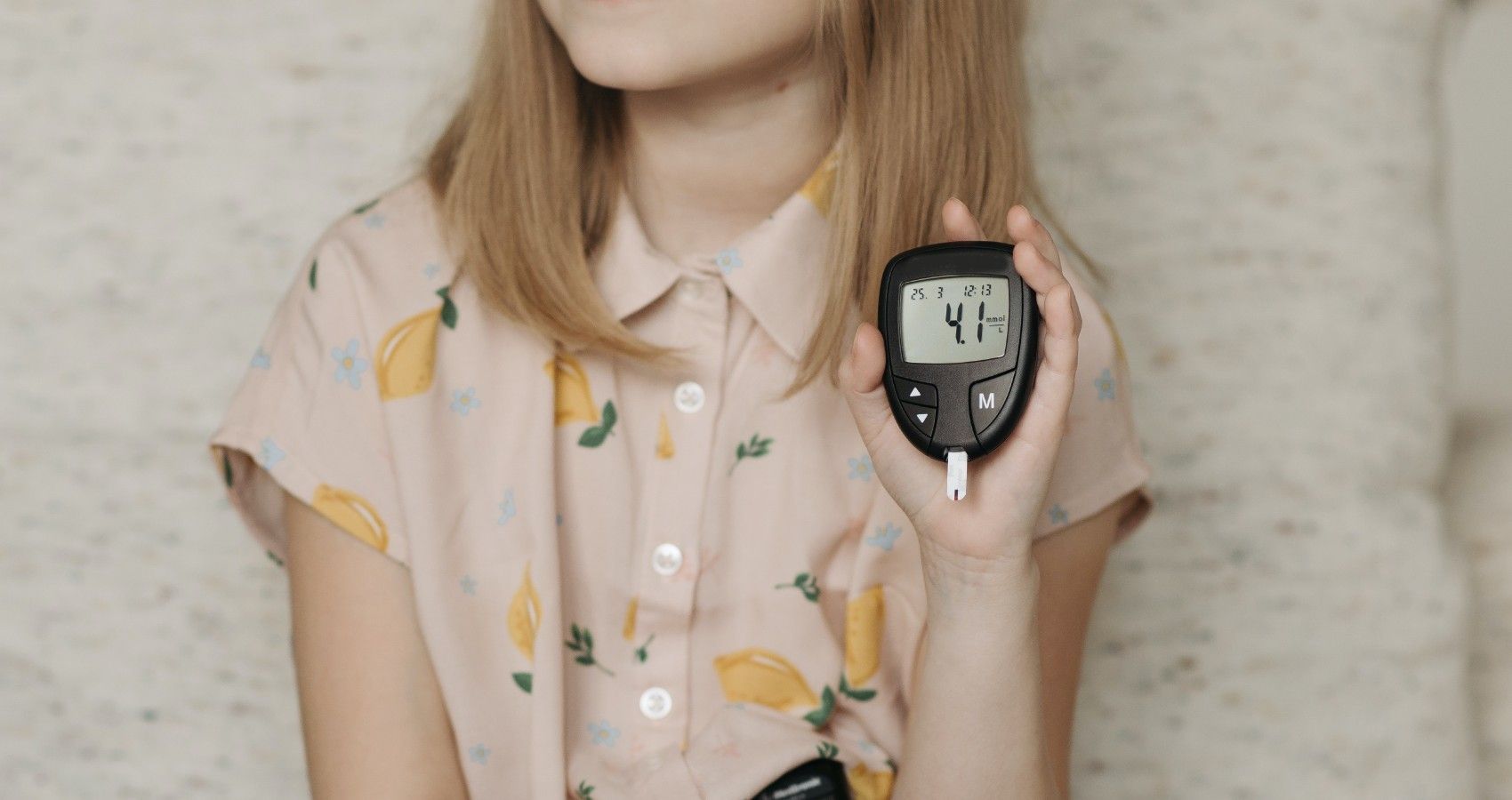 A child showign their diabetes blood sugar monitor