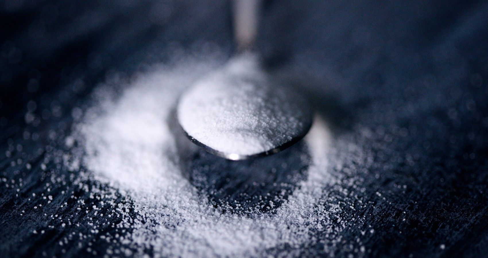 A spoon with sugar on it on a table