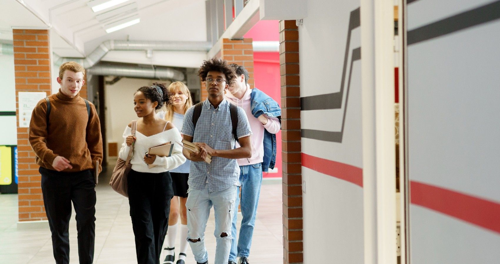 Teenagers walking through school hallway