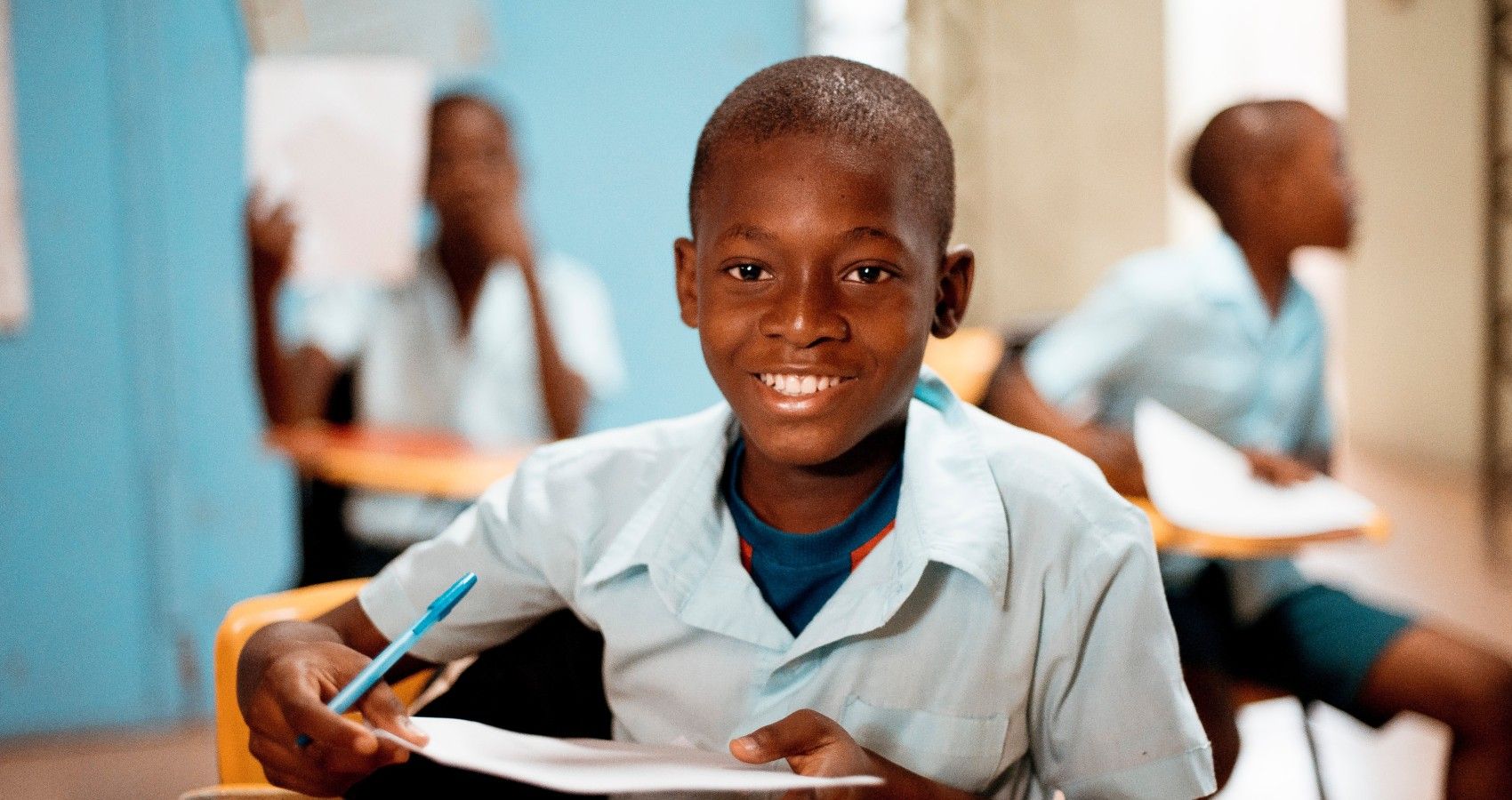 A black student smiling in a classroom