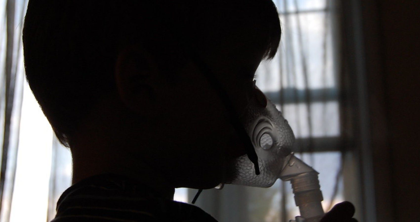 A child using an asthma inhaler on mouth