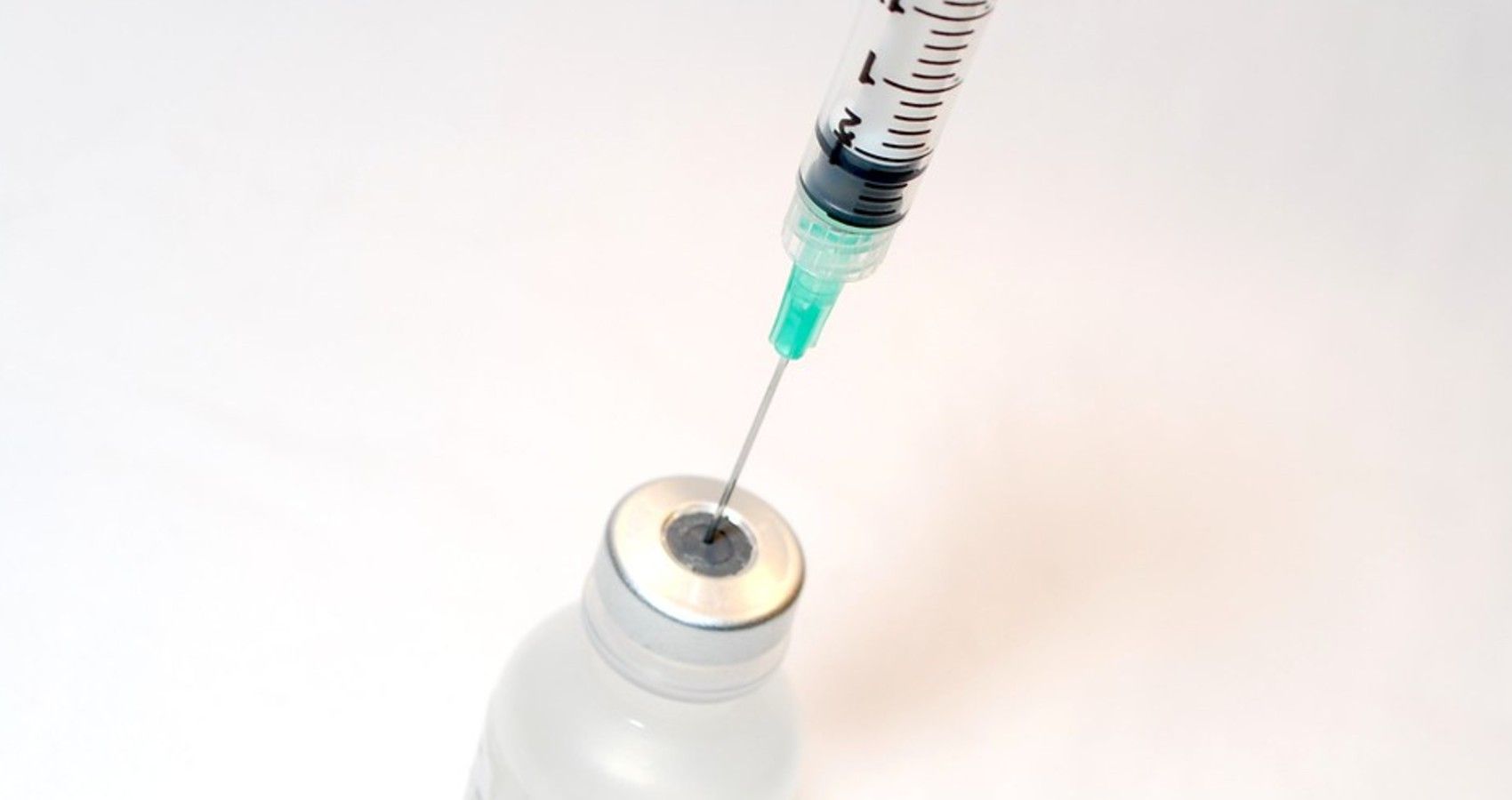 A syringe needle going into a vial