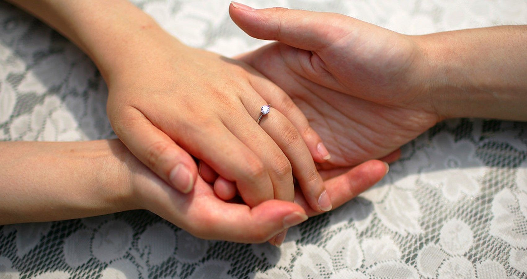 A woman's hands holding on to a males hand