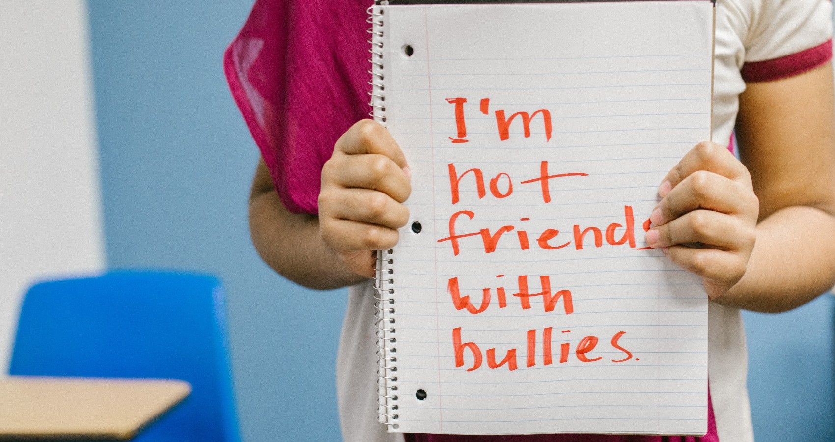 A child holding up a sign about bullying