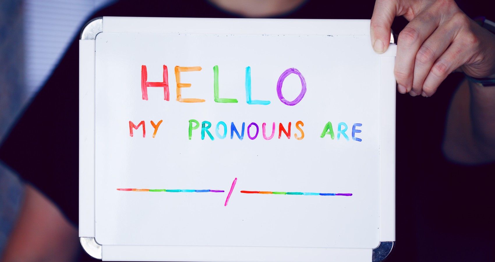A person holding up a pronoun sign