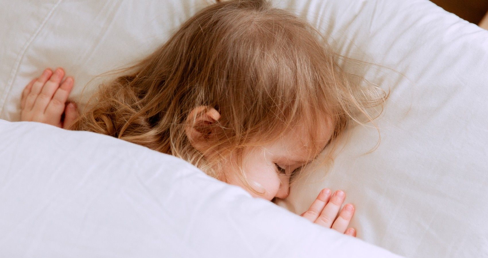 A small child sleeping in a bed
