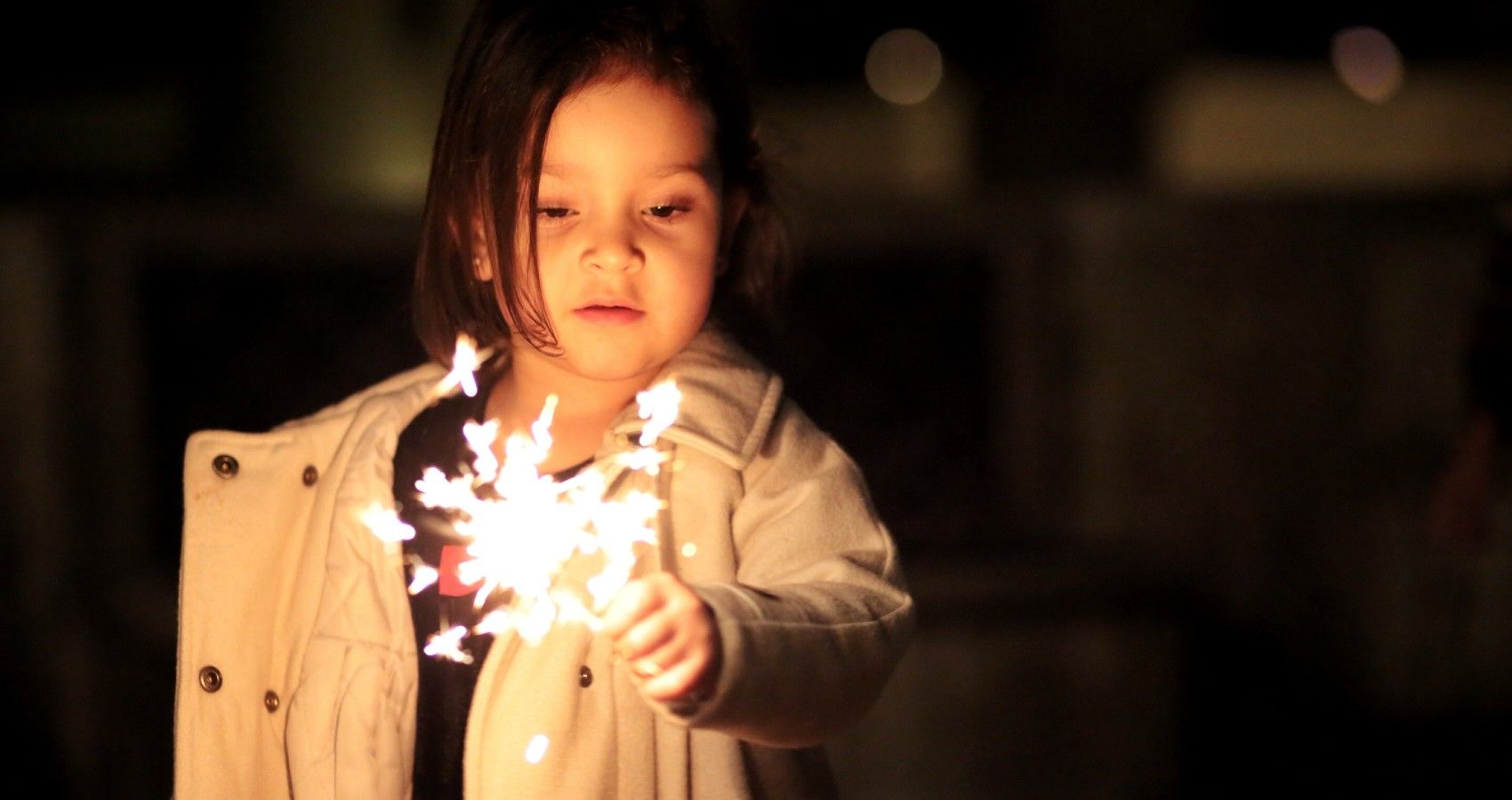 a yougn child using a sparkler firework