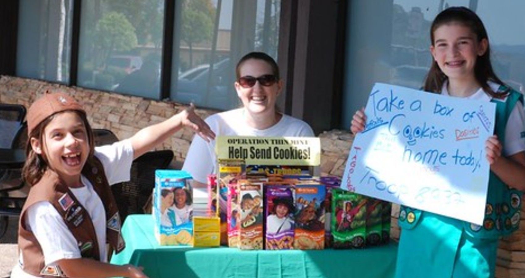 A mom and her daughers selling girl scout cookies