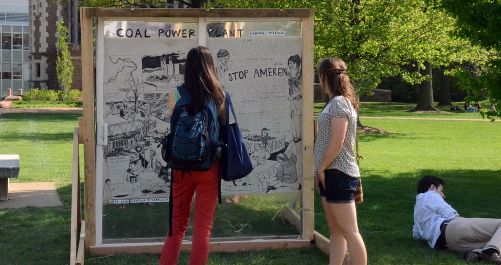 students looking at a climate change action board outside