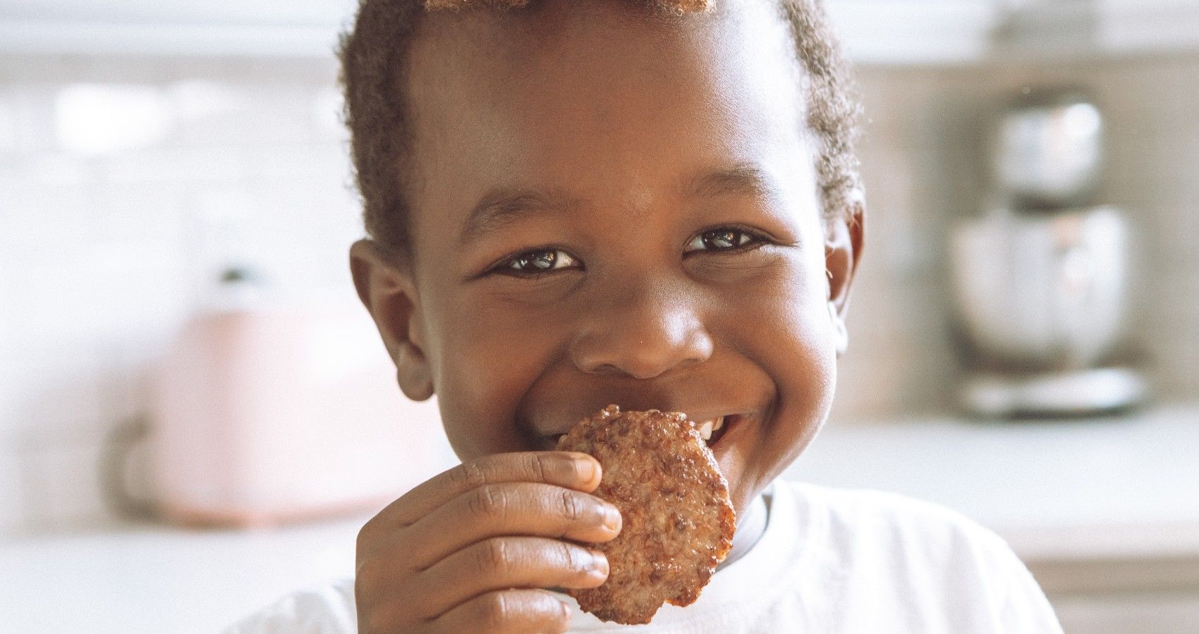 A Child Eating A Small Cookie