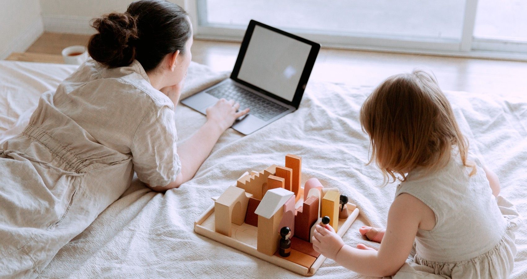 A Mother On Her Computer While Her Daughter PLay