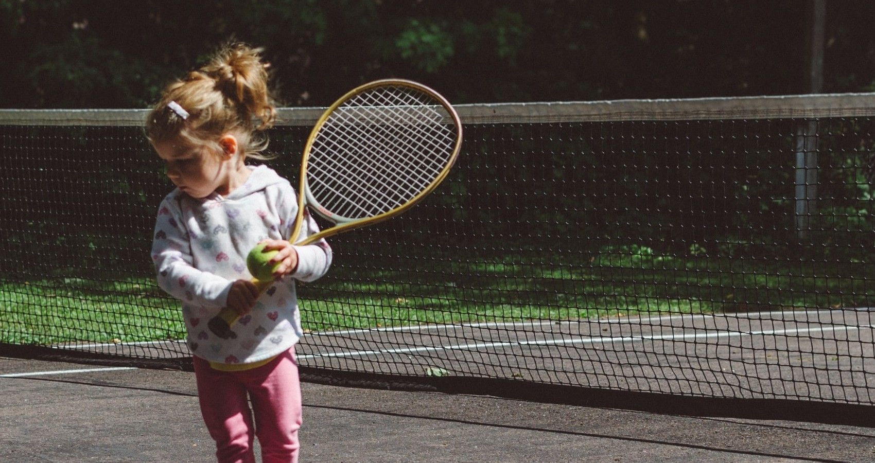 A Young Girl Playing Tennis On A Court