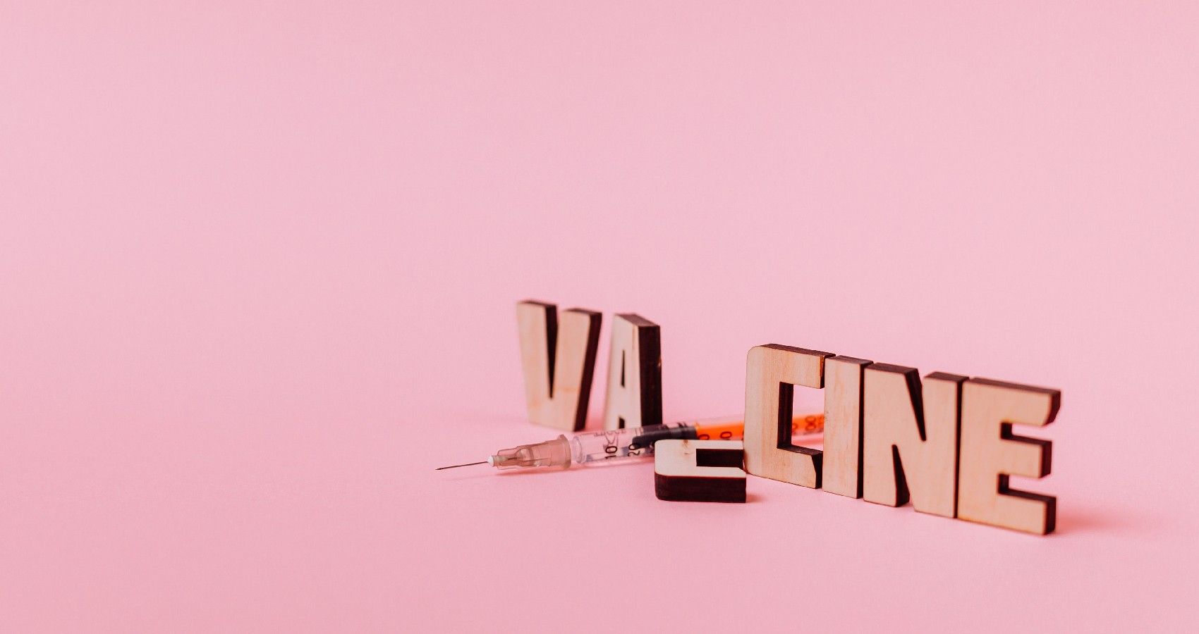 A Pink Background With The Word Vaccine And Syringe On It
