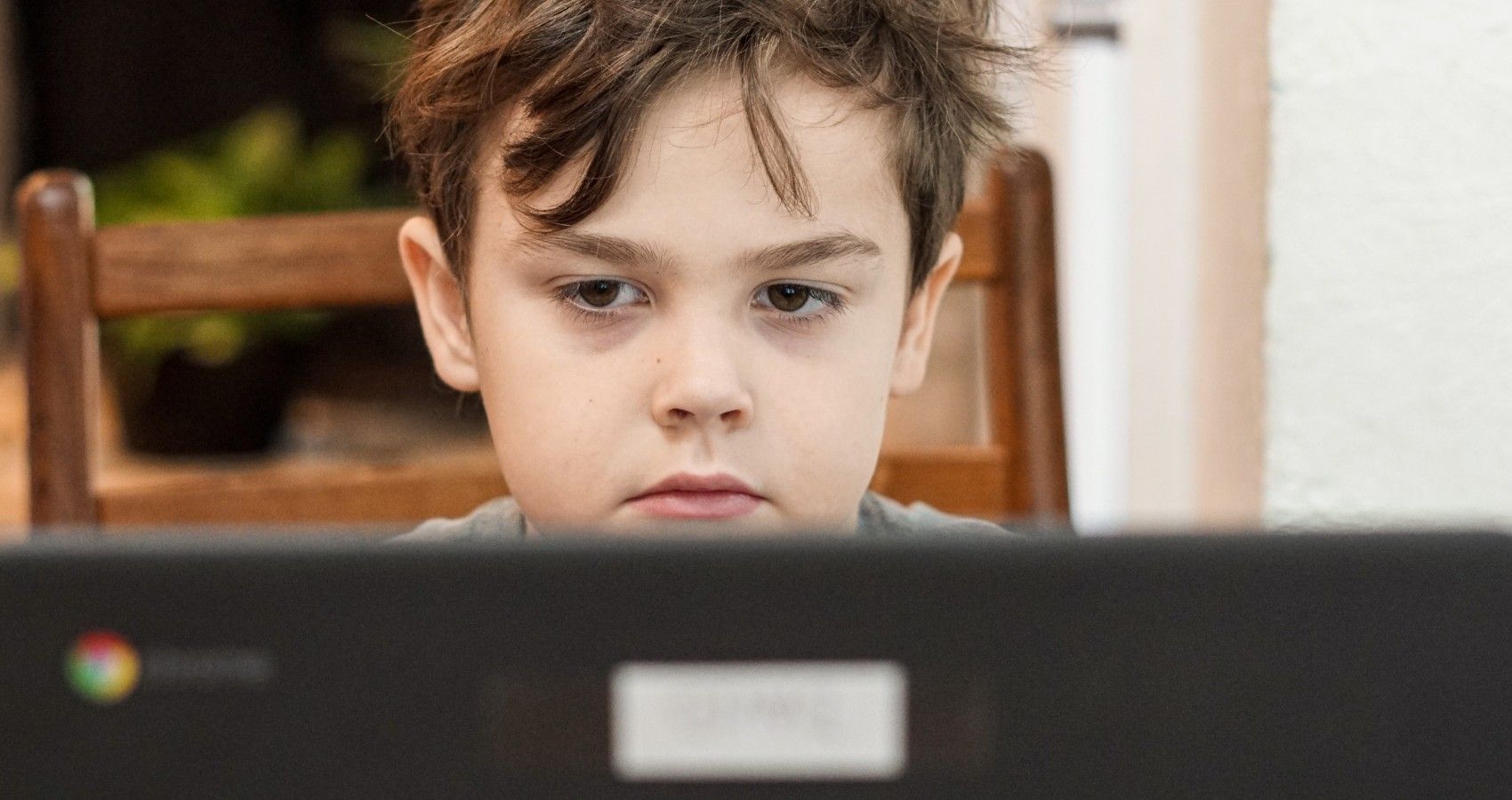 A Young Boy Sitting At A Computer