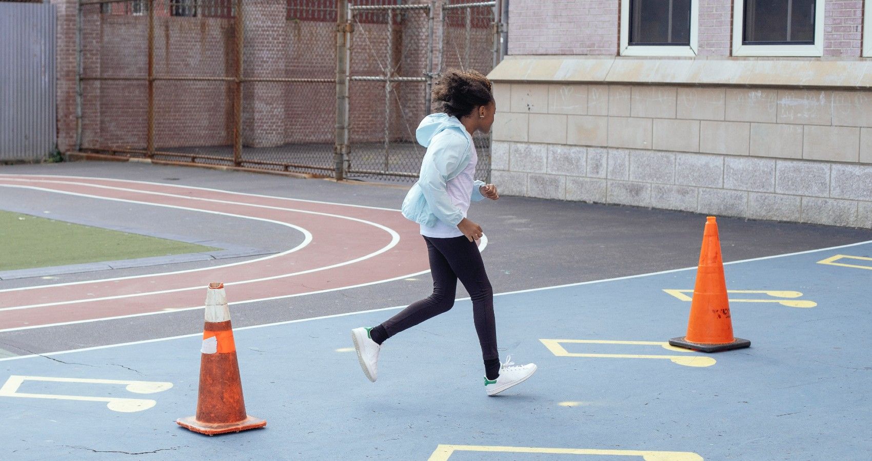 A Young Girl Running Outside In Gym Class