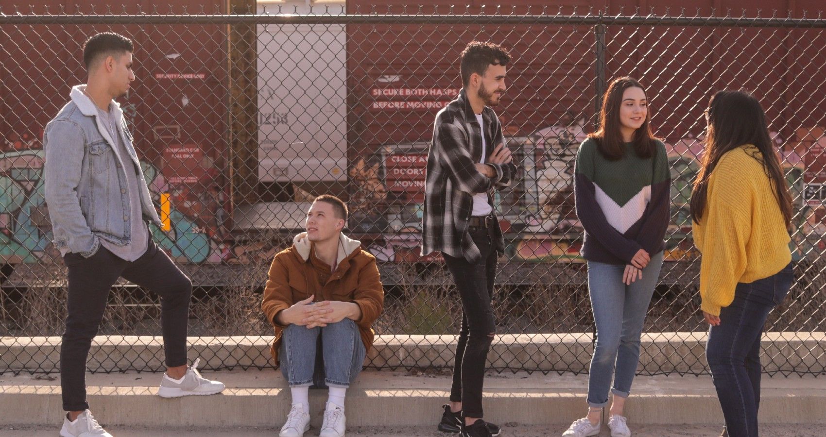 A Group Of Teenagers Standing And Talking To Strangers