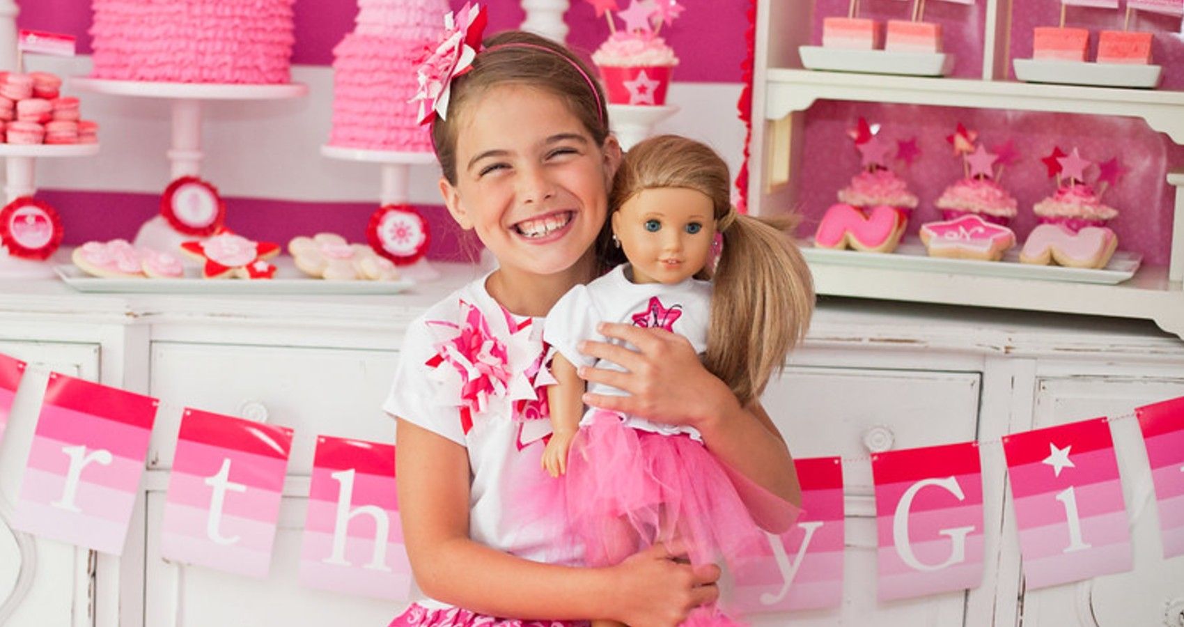 A Girl Holding An American Girl Doll Up