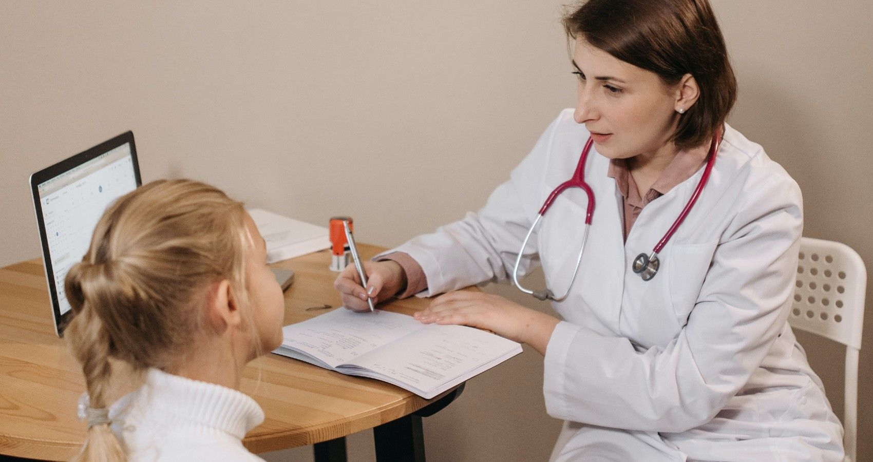 A Pediatrician Talking To A Small Child In An Appointment