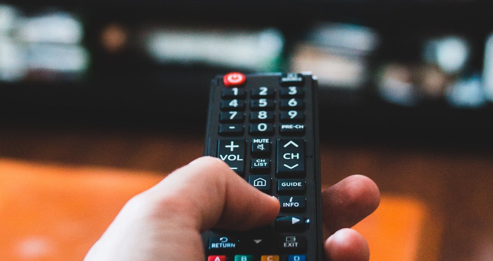 A Person Pointing The Remote At The TV