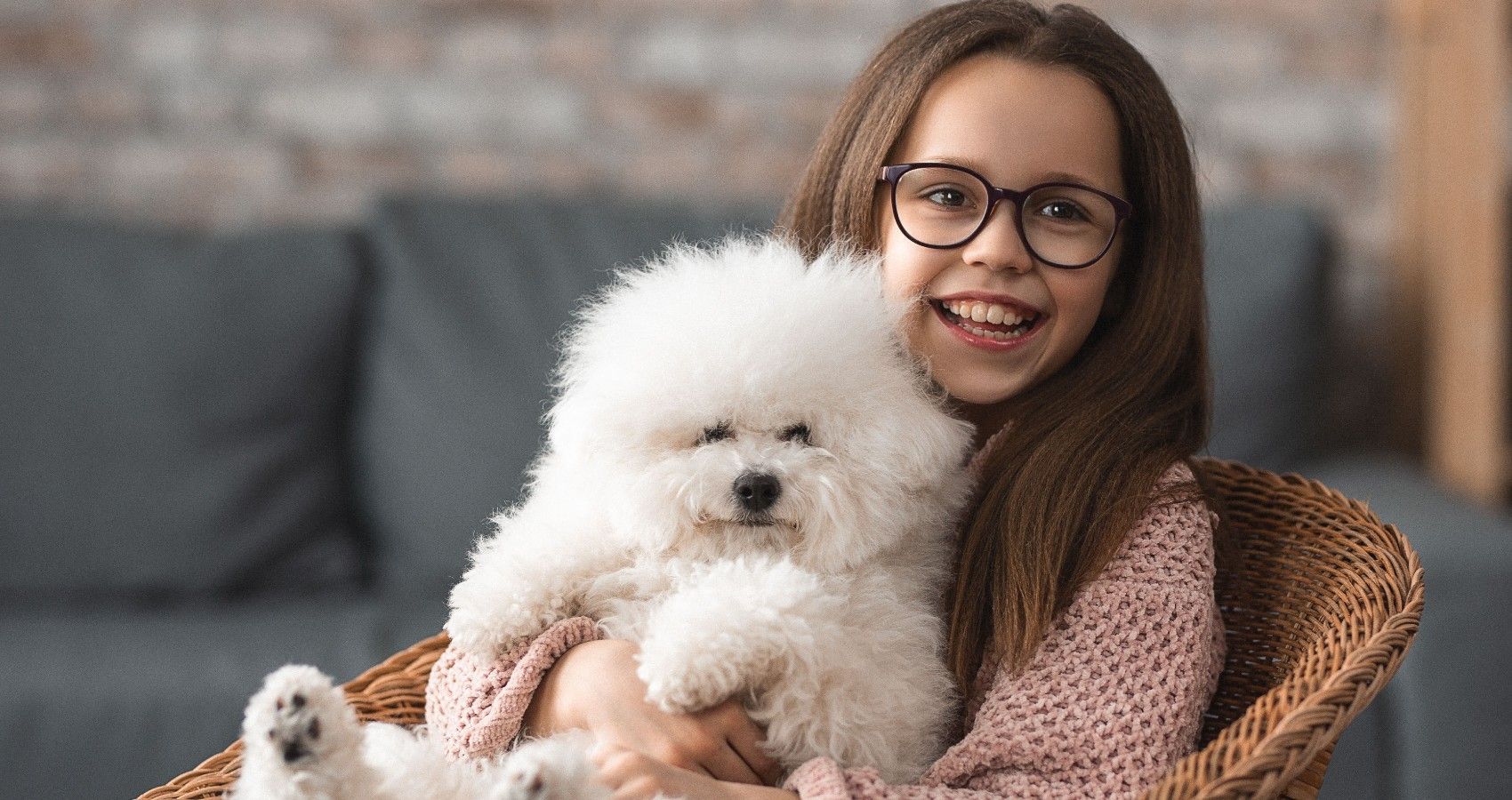 A Child Holding A Small Dog