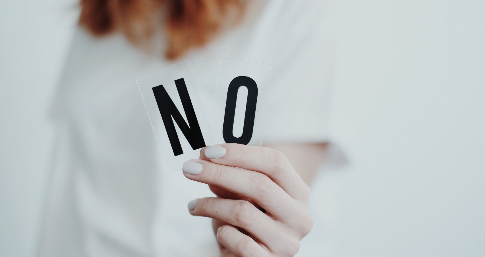 a woman holding up the word no