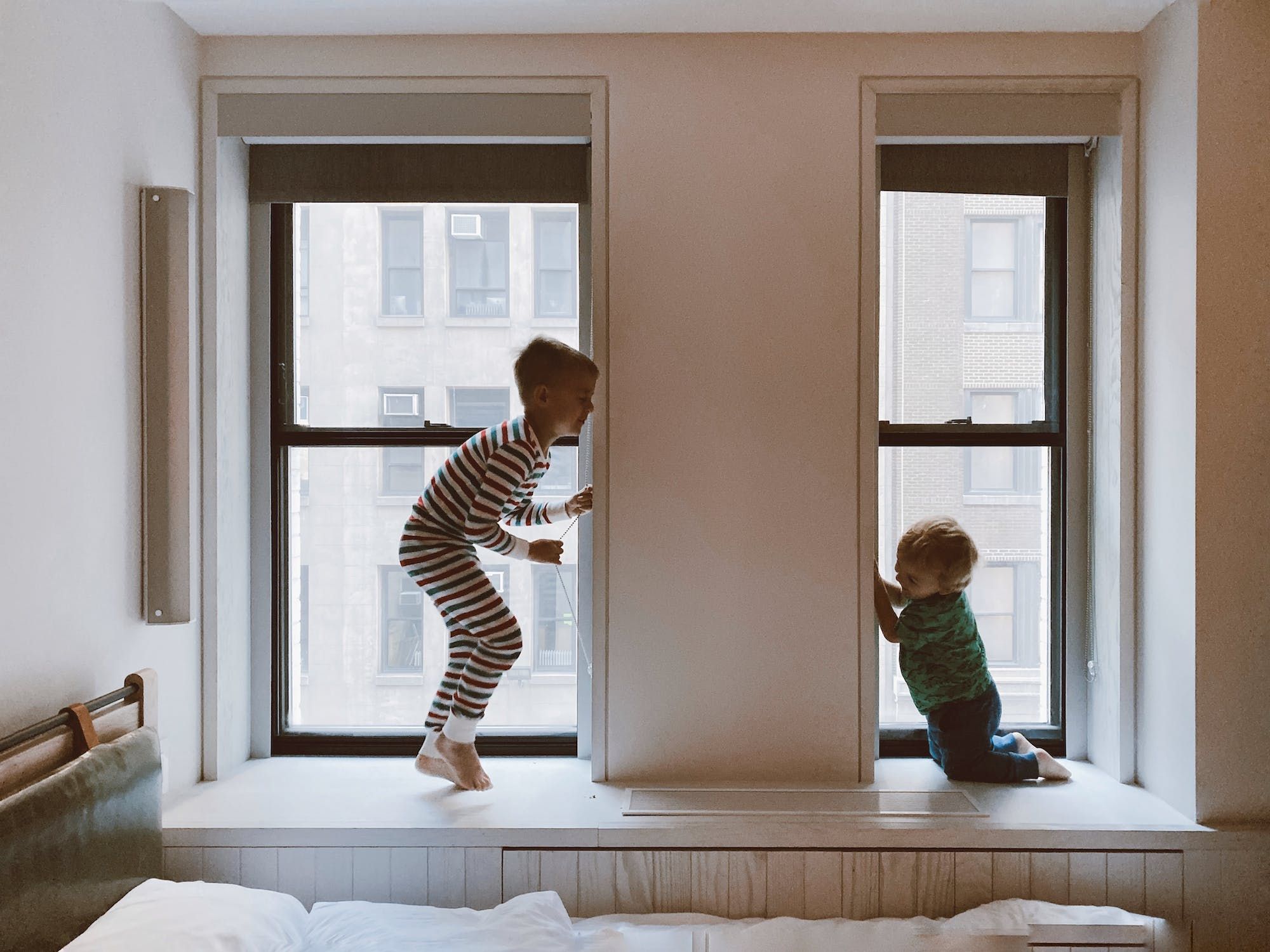 Two kids playing in apartment windows