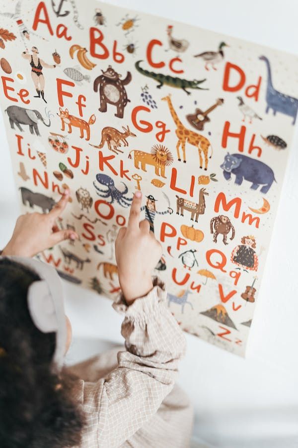 Child pointing to phonics pictures and letters