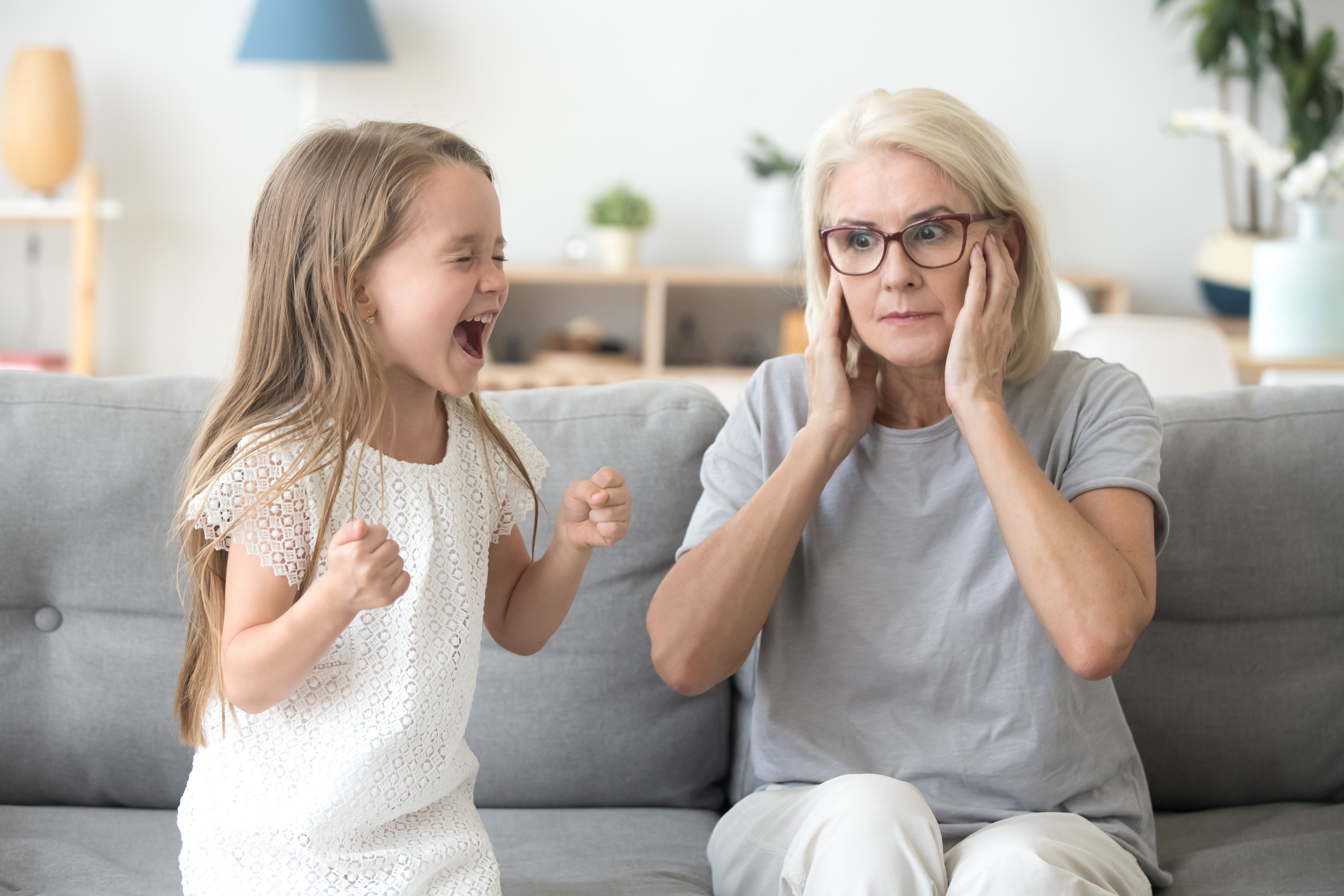 child screaming, grandparent with hand over ears