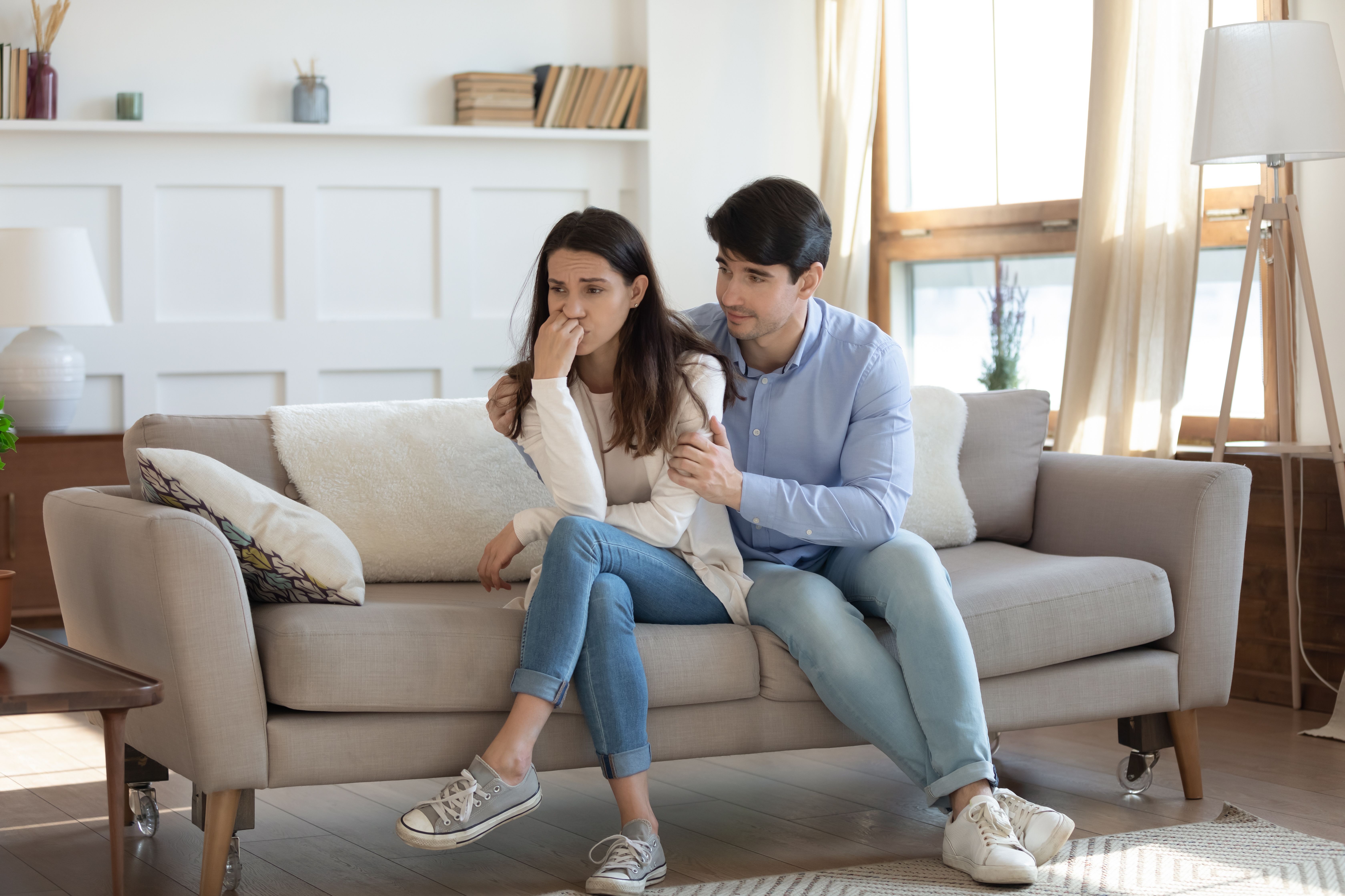 couple sitting on couch, woman upset