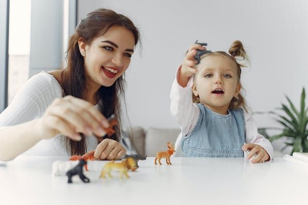 Mom playing dinosaurs with daughter
