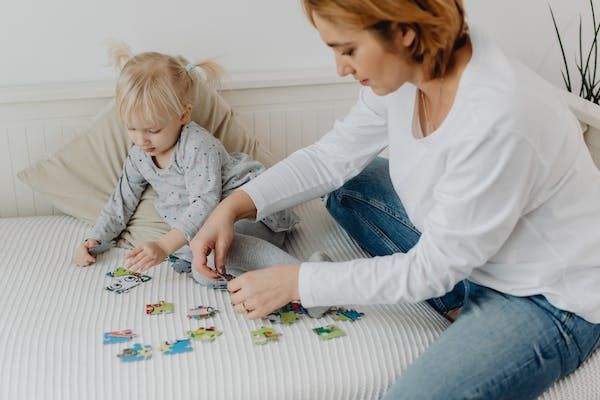 Mom doing puzzle with preschool child