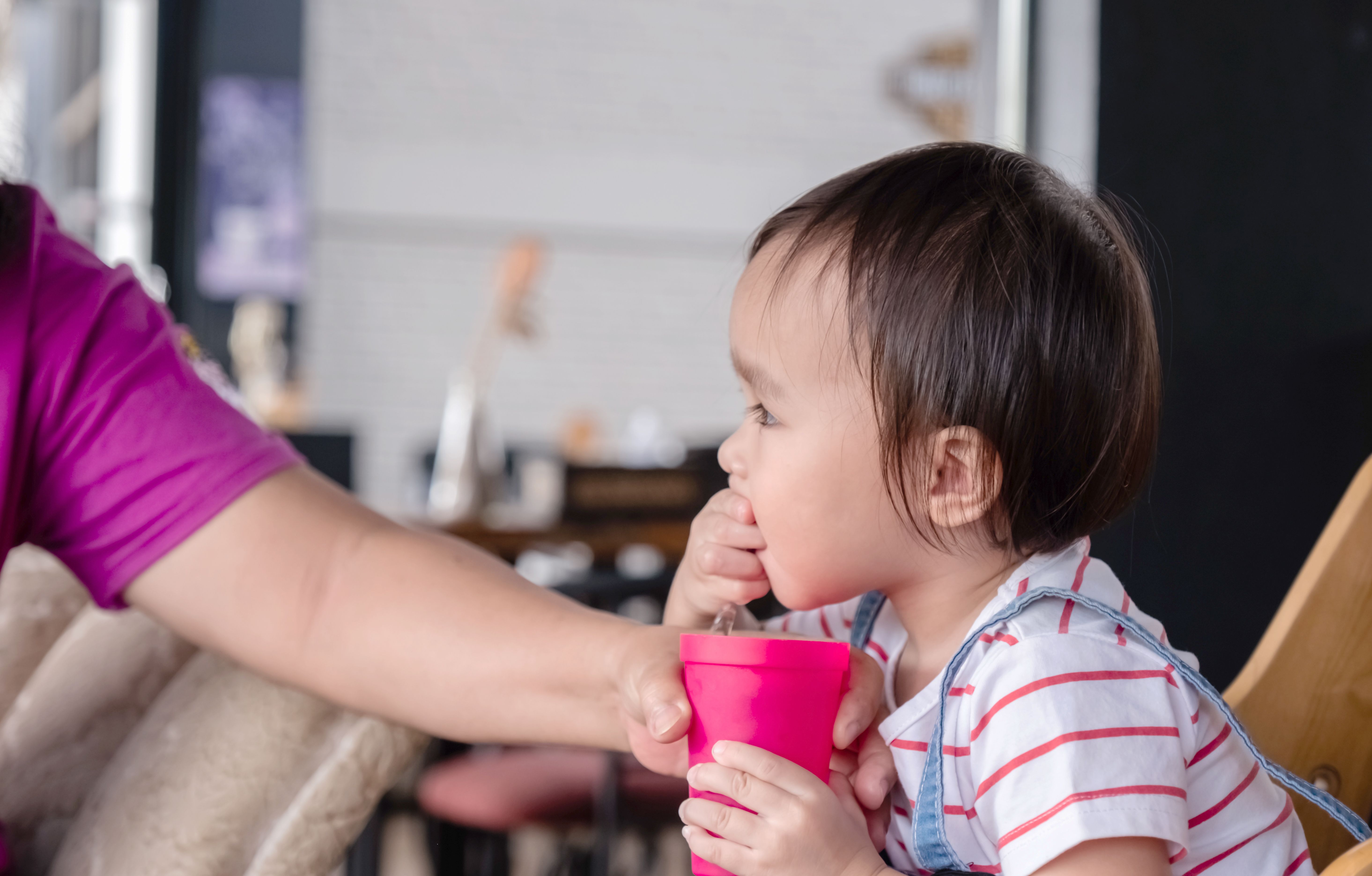toddler eating ice from cup